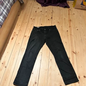 Svarta Levi's 511 Premium jeans - Svarta Levi's 511 Premium jeans med klassisk femficksdesign och raka ben. Jeansen har en snygg, mörk tvätt och är tillverkade i slitstarkt denim. Passformen är modern och straight, perfekt för dig som gillar en clean look.