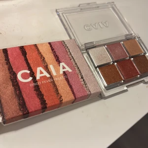 CAIA Disco Fever ögonskuggspalett - Säljer CAIA Disco Fever Eyeshadow Palette med sex skimrande nyanser: vit, rosa, guld, koppar, röd och brons. Paletten har transparent plastförpackning och färgerna heter Diva, Flirty, Shameless, Groovy, Sequin och Last Dance. Helt oanvänd. Prova gärna sänka priset 💞