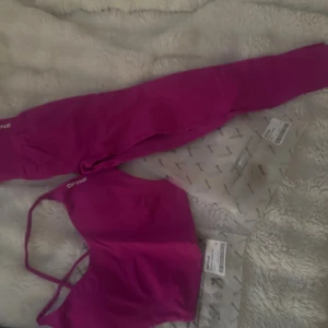 Träningssett från DFYNE - Säljer ett träningssätt från DFYNE med hög midja och tight passform. Materialet är stretchigt syntet som sitter skönt och följer kroppen. Perfekta för gymmet eller sport. Topp storlek M och tights storlek S aldrig använt 