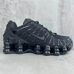 Nike Shox TL Triple Black sneakers - LÄS! Nike Shox TL Triple Black sneakers med helsvart design, ikonisk Shox-dämpning i sulan och mesh- och syntetöverdel. Snygga detaljer med svarta snören, diskret S-logga bak och en futuristisk vibe. Perfekta för dig som gillar streetwear och vill sticka ut. Det star 43cm med det sitter som 42cm sa det funkar bara för dem som har storlek 42cm