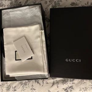 Svarta sneakers från Gucci - Säljer ett par svarta sneakers från Gucci med GG-monogram i tyg och detaljer i skinn. Skorna har rund tå, snörning med svarta skosnören och metallöljetter. Kommer med originalkartong och dustbag. Perfekta för dig som vill ha en clean och lyxig look.