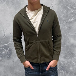 Ralph Lauren Full Zip Hoodie Oliv-Grön - •Ralph Lauren Full Zip Hoodie Oliv-Grön. Skick: 8/10, Inga skador. Storlek: 14/16 år~160-70 cm) Modell: 174 cm, 63 kg. Authentic: ✅. Hör av dig vid frågor eller funderingar, mvh Hessler’s;)
