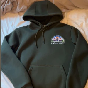 Mörkgrön hoodie Casablanca - säljer en mörkgrån hoodie från casablanca med väldigt hög kvalite och bra passform med ett mindre tryck av deras logga där fram och ett större på ryggen som det visar på bilderna 👍 