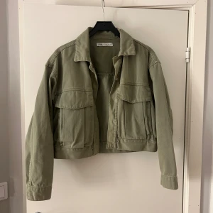 Grön jeansjacka från Zara - Snygg grön jeansjacka från Zara med klassisk krage och stora bröstfickor. Jackan har en croppad passform och knappar framtill. PRIS KAN DISKUTERAS!!🍂🤩