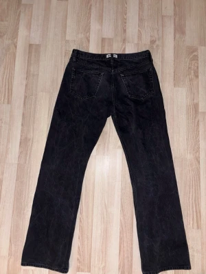 Svarta raka jeansbyxor - Säljer ett par svarta jeansbyxor med raka ben och klassiska bakfickor. Jeansen har en enkel design och de är från hope 