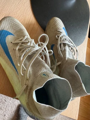 Nike fotbollsskor med blå swoosh - Säljer ett par Nike fotbollsskor i storlek 43. Andvändes i 2 månader innan de blev för små för mig