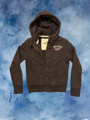 Vintage Hollister Cardigan Med Knappar & Zip (sällsynt) - Säljer denna as feta vintage Hollister caridganen med både knappar och zip | Tröjan är i väldigt bra skick och varmt quiltad vilket gör denna väldigt varm och skön nu under vintern! | Längd ≈ 63cm , Bredd armhåla - armhåla ≈53cm | Modell 175cm, 68kg | Hör av vid ytterligare frågor & priset kan diskuteras vid snabb affär! 