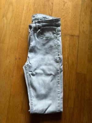 Ljusgrå jeansbyxor med skinny&slim fit - Snygga ljusgrå jeansbyxor från ISBN med klassisk femficksdesign och raka ben som smalnar av mot ankeln. Byxorna har en modern tapered passform och är tillverkade i mjukt bomullsmaterial med lite stretch för extra komfort. Perfekt för dig som gillar stilrena och enkla jeans. Skriv för mer bilder frågor. Pris kan diskuteras 