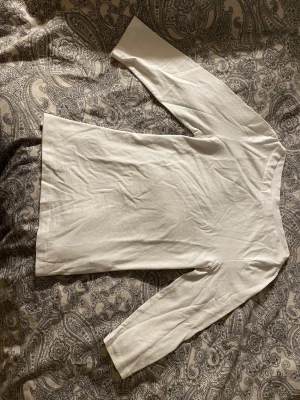 Vit trekvarts ärmar  topp i bomull - Säljer en enkel och stilren vit långärmad topp i mjuk bomull. Modellen är rak med rund hals.  Toppen är helt utan mönster och har en klassisk look som funkar året runt.💕