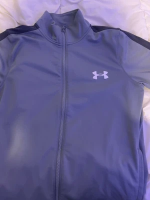 Svarta jeans, under urmed,mckenzie t-shirt, pier one T-shirt  - Säljer ett par svarta jeans från DSQUARED2 med coola vita och röda färgstänk samt slitningar och tvättade detaljer. Jeansen har klassisk femficksdesign och knappgylf. Perfekt för dig som gillar streetstyle och vill sticka ut.