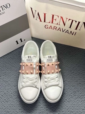 Valentino Rockstud sneakers vit/rosa - Säljer ett par Valentino Rockstud Untitled sneakers i vitt skinn med ljusrosa band och ikoniska nitar. Skorna har rund tå, platt sula och snörning. Perfekt för dig som gillar lyxiga detaljer och vill sticka ut med en snygg design.