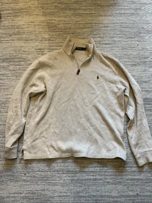 Beige half zip tröja från Polo Ralph Lauren - Säljer en beige långärmad tröja från Polo Ralph Lauren med half zip. Storlek M och bara använt fåtal gånger