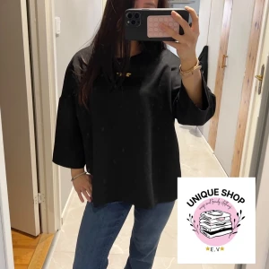 Svart loose Trekvartsärmad tröja - En svart, loose fit tröja med rund halsringning och långa, vida ärmar. Enkel och stilren design utan synliga detaljer eller mönster. Perfekt för dig som gillar en avslappnad och clean look. Passar till jeans eller kjol för en chill vibe.