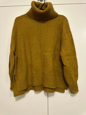 Polotröja från H&M - Säljer en polotröja från H&M i storlek S. Tröjan har en bred, ribbad polokrage och ribbade muddar vid ärmslut och nederkant. Modellen är loose fit med långa ärmar och mjukt stickat material som känns skönt mot huden.