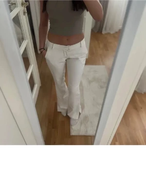 Vita bootcut-byxor från BikBok - Snygga vita bootcut-byxor från BikBok i storlek 36. De har klassisk midja, bälteshällor och fickor både fram och bak. Materialet är mjukt och känns som bomull med lite stretch. Perfekta för dig som gillar en clean och fräsch look.