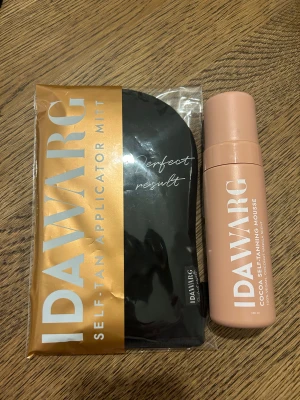 Ida Warg brun utan sol mousse + appliceringsvante - Säljer ett set med Ida Warg Cocoa Self-Tanning Mousse och en svart self-tan appliceringsvante. Moussen kommer i en beige plastflaska med kokos- och vaniljdoft, 100% vegansk. Vanten är svart och används för att applicera produkten jämnt på huden. Helt oanvänt!!!