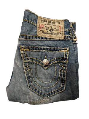 True Religion Jean Ricky Super T - True Religion Jeans, Vintage Tab, Storlek 31, bra skick, knä ditressing, midja: 41cm, längd 109cm, innerben 82cm och benöppning 21cm. Skriv om ni något mer 📲
