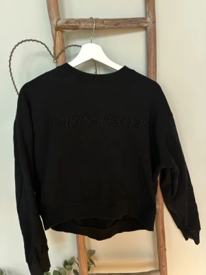 Svart sweatshirt Carin Wester XS - Cool svart sweatshirt från Carin Wester med broderad logga på bröstet. Tröjan har rund halsringning, långa ärmar och är gjord i mjukt sweatshirtmaterial. Perfekt för en avslappnad och trendig look.