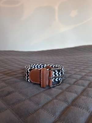 Svart vitt flätat bälte - Tja det är helt nytt från bältgallerian i storlek 105cm långt och 3,5cm brett. Det är gjort i ett elastiskt material och man kan anpassa längden vart man än vill. Om du inte gillar den här färgen finns flera andra att välja mellan. Desto mer du köper desto billigare blir det. Säljer också armband.