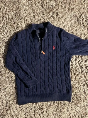 Mörkblå kabelstickad tröja Polo Ralph Lauren🙌🤩 - Mörkblå kabelstickad tröja från Polo Ralph Lauren med halv dragkedja och ribbad krage. I riktigt bra skick och pris går att diskuteras!🙌🤩