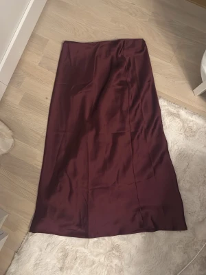Vinröd långkjol från Zara - Säljer en stilren vinröd långkjol från Zara. Den är aldrig använd 