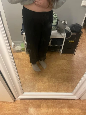 Svarta vida linnebyxor - Säljer ett par svarta linnebyxor med rak och avslappnad passform. Byxorna har hög midja och vida ben, perfekta för en chill och stilren look. Materialet är linne som ger en luftig känsla. Inga synliga detaljer eller märke.