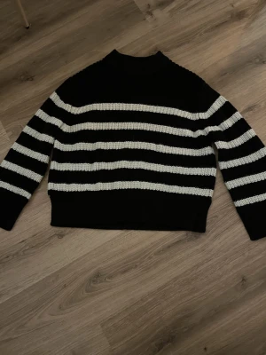 Svartvit randig stickad tröja -  svart stickad tröja me vita ränder. 