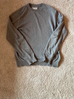 Grå basic sweatshirt - En enkel och stilren grå sweatshirt med rund hals och långa ärmar. Tröjan har ribbade muddar vid ärmslut och nederkant. Perfekt för en avslappnad och clean look.