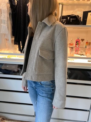 Beige Zara jacka - Stilren beige cardiganjacka med krage och stora fickor framtill.  Zara jackan är en gammal model därav finn inte kvar! Passa på!!!