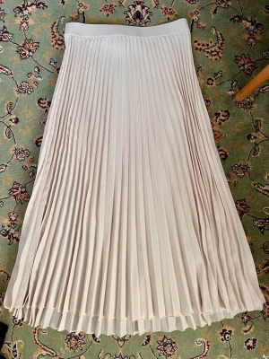 Maxikjol pleated/veckad cremevit - Längd: 83 cm🌸 Midja: 36 cm, men är resår i och stretch. Se bilder för skick 🌸