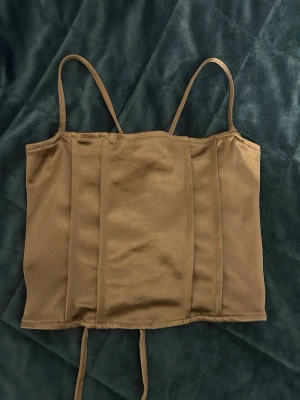 Brun satin topp - Topp från h&m som man kan knyta vid ryggen, passar därför även storlek S