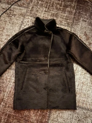 brun pälsjacka med hög krage - Snygg brun pälsjacka med rak passform och hög krage. Jackan har knäppning framtill och två snedställda fickor. Materialet är mjukt och ger en lyxig känsla. Aldrig använd!Pris kan diskuteras 