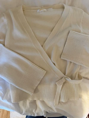 Vit omlottkofta  - Mysig beige omlottkofta från Gina! Storlek 170 vilket jag skulle säga passar som s eller m beroende på hur oversized man vill ha den. Vida, mysiga armar! Jättebra skick endast använd någon enstaka gång. 