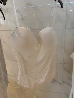 Vit korsettopp- Lindex - Jättefin vit Korsettopp från Lindex i storlek 75C (XS/S). Man kan justera banden samt ta av dem helt, du kan dessutom ändra hur tajt den ska sitta genom bh-knäppena. Säljs inte längre på Lindex. För mer info eller bilder kom PM! 💗
