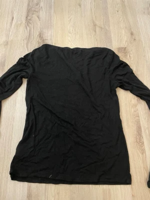 Svart långärmad topp från Gina Tricot - En enkel svart långärmad topp från Gina Tricot. Modellen är rak med rund halsringning och tillverkad i mjukt bomullsmaterial. Perfekt basplagg att styla med olika outfits och är bra till att styla!!💕