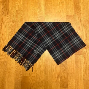 Mörkblå Burberry halsduk i kashmir - Säljer en mörkblå halsduk från Burberry. Halsduken är gjord i 100% kashmir och är i gott skick. Var inte rädd för några frågor.