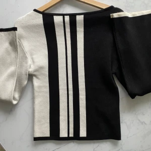 Svartvit randig tröja Gina Tricot XS - Cool svart och vit tröja från Gina Tricot i storlek XS. Tröjan har breda, långa ärmar och ett grafiskt randigt mönster framtill och baktill. Materialet är mjukt och stickat, perfekt för dig som gillar en unik och trendig look. Figursydd å slutsåld på hemsidan 