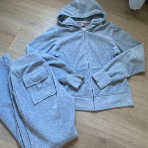 Juicy Couture set - Säljer ett grått set från Juicy Couture som ger dig en riktig BBL effekt. Tjejer jag lovar er! Settet är i mjuk velour med dragkedja och huva. Kom privat för frågor eller fler bilder. Säljer via min vinted endast : mimmilur11