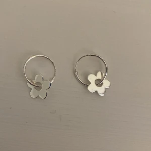 Silvriga hoopörhängen med blommor - Riktigt silver, hoop örhängen med blommor.