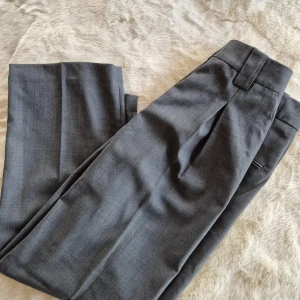 Kostymbyxor i ullmix  -  nya. Jag upplever att dem är små i storleken då dem inte passar mig som vanligtvis har storlek 38. Mått i midjan är 75-76cm (lite svårt att mäta exakt) längden är ca 95cm. Säljer även ett par marinblåa i samma modell och storlek. Katt finns i hemmet. 