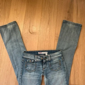 Lågmidjade bootcut jeans från Only - Snygga ljusblå jeans från Only med låg midja och bootcut-ben. Storlek 32-34. Säljer för att den är för små. Jeansen har ett litet hål men går lätt att laga. Midjemått 38cm. Innebredslängden 80cm. Ytterbenslängd 96cm. Från midja och ner 17cm
