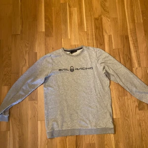 Grå Sail Racing sweatshirt - Snygg grå sweatshirt från Sail Racing med svart logga tryckt över bröstet. Nypris 600kr