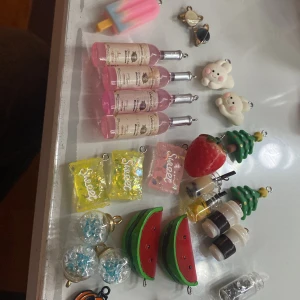 Färgglada berlocker till smycken - Säljer ett mixat set med söta och färgglada berlocker, perfekta att använda till halsband, armband eller örhängen. Setet innehåller berlocker formade som glassar, vattenmelon, julgranar, drycker, godis, planet, krona, blomma, donut och nalle. Färgerna är rosa, blå, gul, grön, röd, vit, guld och svart.