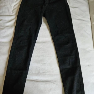 Svarta skinny jeans i storlek S - Svarta jeans med skinny passform, tillverkade av 85% bomull, 13% polyester och 2% spandex. Snyggt smala ben och klassisk look som funkar till sneakers eller boots. Perfekt för dig som gillar stilrena och tajta jeans.