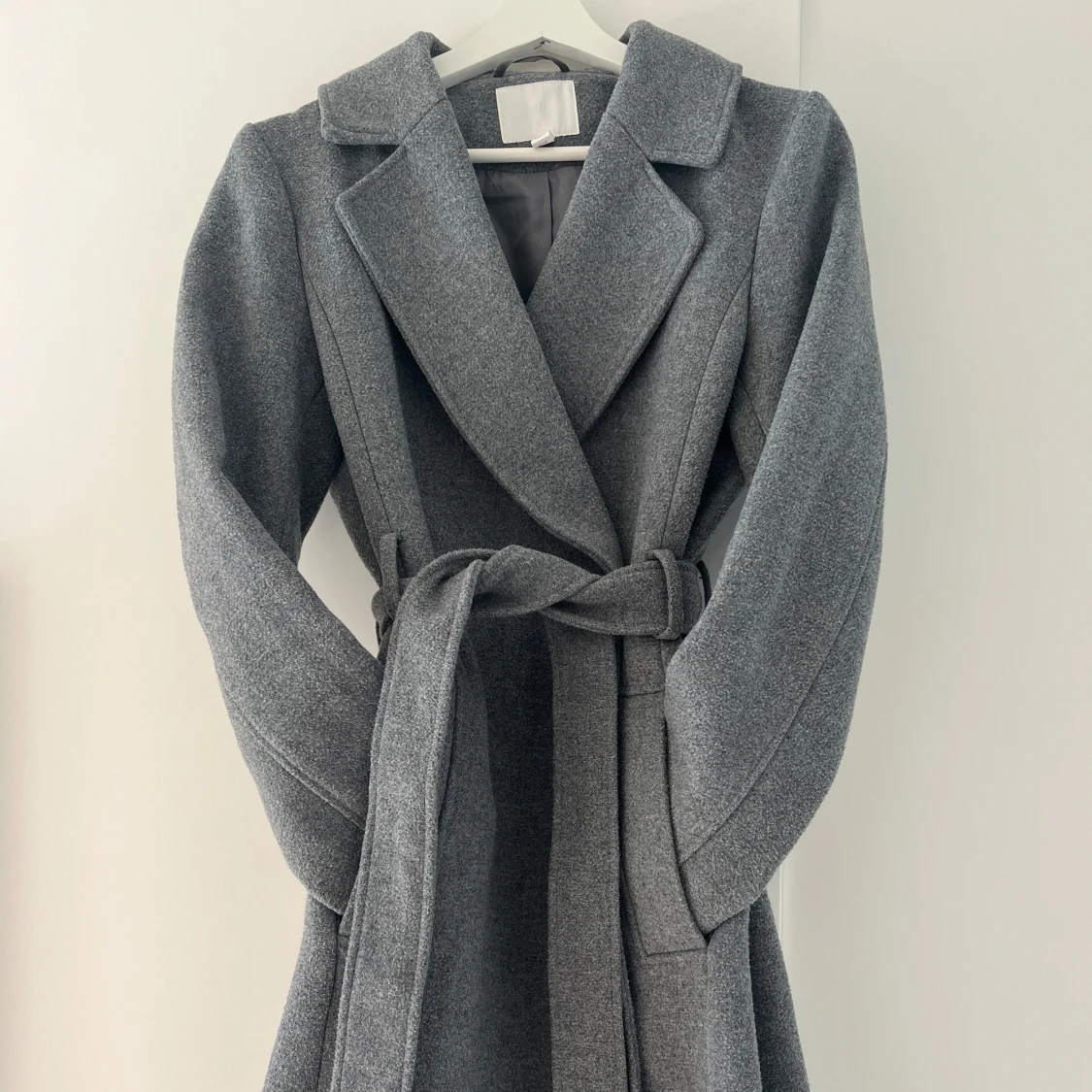 Grå kappa med bälte och knappar