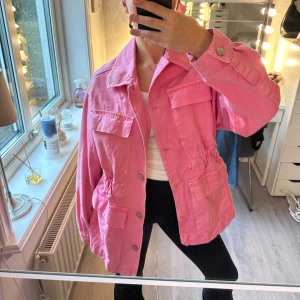 skrikrosa overshirt/jeansjacka med fickor - Säljer en rosa overshirt med flera stora fickor och knappstängning framtill. Jackan har en loose passform och elastisk midja som ger en snygg siluett. Perfekt att slänga över en t-shirt för en chill look. Använd ganska flitigt men håller fortfarande orginalskick 💞