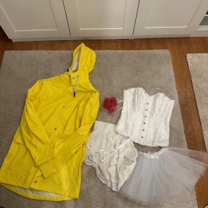 Par halloween kostym  - Kostym till it och jacka till barnet med röd ballong.  Man får med: -Gul regnjacka, den är använd med i fint skick. Herr storlek+dubbel storlek (S/M) från lager157. -Vit korsett, den är helt ny från shein. Storlek S. -vit/creame färgad kjol från lager157 använd men fint skick, storlek 160= ca XS. -Puffig kjol, liten i storlek, helt ny från shein. -plast blommor, som man kan ha som knappar så som pennywise har.  Vid frågor så är det bara att skriva! 