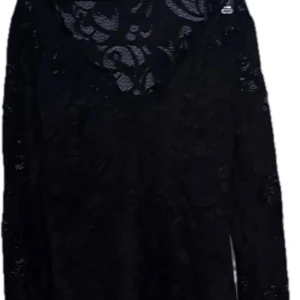 Svart spetsblus från Gina Tricot - Svart långärmad blus i genombruten spets från Gina Tricot. Toppen har v-ringad hals och är tillverkad i stretchigt material. Perfekt för dig som gillar en elegant och edgy look med transparenta detaljer. 