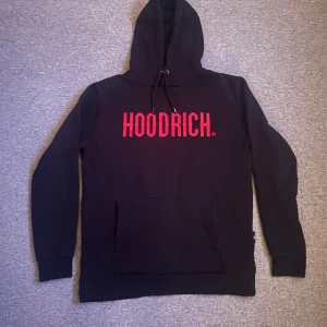 Hoodrich OG Core tracksuit - Hoodrich OG Core tracksuit. Säljer en svart hoodie och matchande byxor från Hoodrich. Hoodien har en stor röd logga på bröstet och en praktisk magficka. Byxorna har en liten röd logga på ena benet och justerbar midja med snörning. Perfekt för en avslappnad stil. Skicket är 10/10.