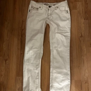 lågmidjade vita jeans - jättesnygga lågmidjade vita jeans som passar till allt. passar mig med w26, längd 30